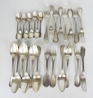 un grand nombre de cuillères et de fourchettes en argent disposées sur une table