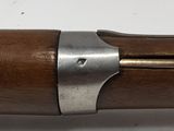 an old gun with a wooden barrel on a white surface