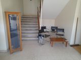 a room with a table, chairs, and stairs in it
