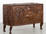 un vieux coffre en bois orné de sculptures, dans une pièce