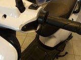 a white scooter with black handlebars and a black seat