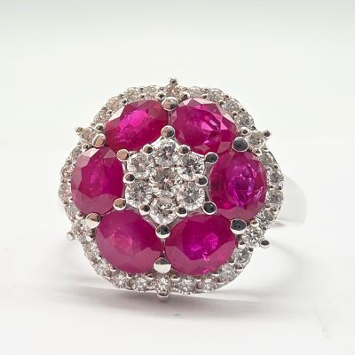 une photo d'une bague sertie d'un diamant rose et blanc, posée sur une surface blanche
