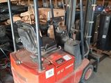 a red forklift truck parked in a garage