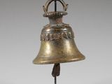 brass bell on a black stand with a white background