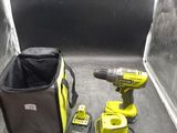 a cordless drill and two batteries on the floor