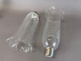 two empty glass bottles sitting on a table next to each other