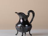 a black pitcher sitting on a white table