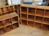 Dans une pièce, trois bibliothèques en bois sont empilées les unes sur les autres