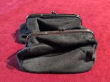 two black purses sitting on a red carpet