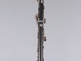a black and silver clarinet sitting on top of a clear stand