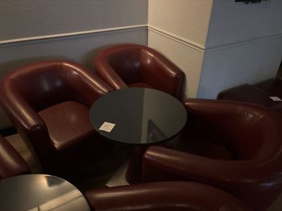 des fauteuils en cuir et une table ronde dans la salle d'attente d'un hôtel