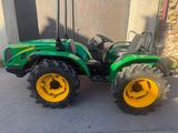 a picture of a green tractor parked in front of a building