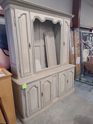 une armoire blanche avec une porte vitrée au milieu d'une pièce