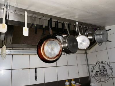 pots and pans hanging from the ceiling of a kitchen