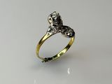 a close up of a gold and silver ring on a white surface