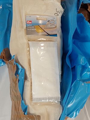 un paquet de papier toilette posé par terre à côté d'un autre paquet de papier toilette