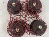 three black balls with red string wrapped around them on a white surface