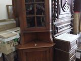 une armoire en bois avec une porte vitrée dans une pièce remplie de cartons