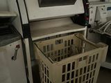 a machine that is sitting next to a laundry basket