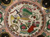 a plate with a picture of a bird and flowers on it