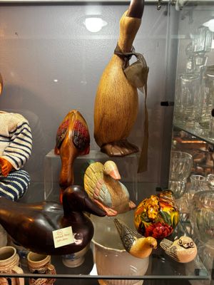 une vitrine contenant divers oiseaux et vases en bois