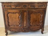 une vieille armoire en bois ornée de sculptures élaborées sur le dessus