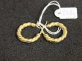 une paire de boucles d'oreilles en or sur une surface noire