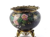 a vase with flowers painted on it sitting on a stand