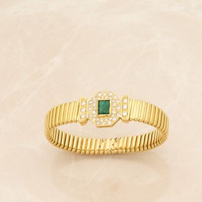 a close up of a gold bracelet with a green stone
