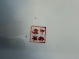 a white plate with a red design on it