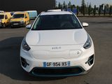 une voiture blanche garée sur un parking, avec d'autres voitures en arrière-plan