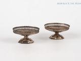 pair of silver plated bowls on pedestals on a white background