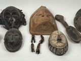 ensemble de masques africains posés sur une surface blanche, sur fond blanc