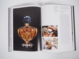 an open book with a picture of a perfume bottle on it