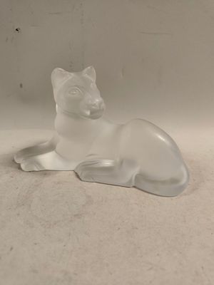 a glass figurine of a cat sitting on a table