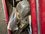 a red metal cabinet with a bunch of items inside of it