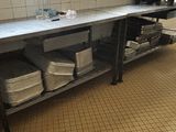 une cuisine avec un plan de travail et un évier sur lequel sont posés de nombreux plats