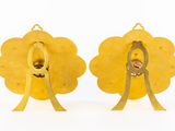 pair of gold earrings with a red stone in the middle of each ear