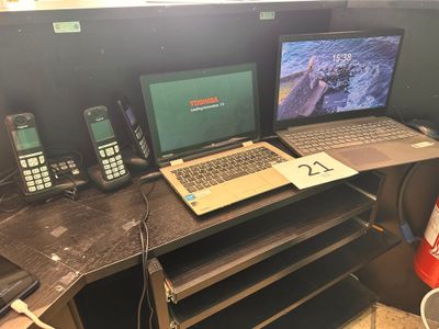 a desk with two laptops and two cell phones on it