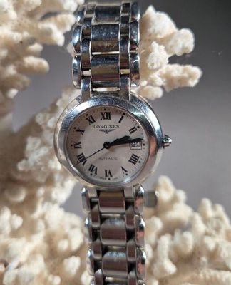 une montre en argent avec des chiffres romains sur le bracelet
