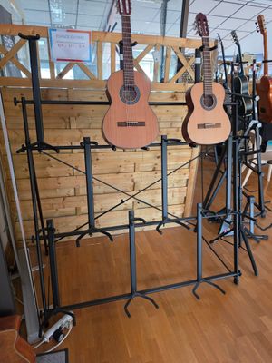 many guitars on display in a room with wood flooring