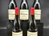 quatre bouteilles de vin sont posées sur une table noire