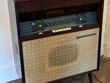 an old radio sitting on top of a wooden cabinet