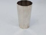 a small silver cup on a white surface