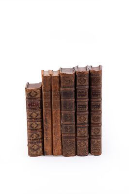 plusieurs vieux livres empilés sur une surface blanche
