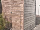 a small wooden shed sitting in the middle of a driveway