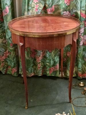 a small table with a wooden top on a green carpeted floor