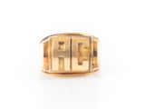 gros plan d'une bague en or sur une surface blanche