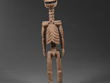 une figurine en bois représentant un squelette avec un corps humain