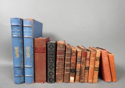several old books are lined up in a row on a gray surface